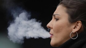 A woman smokes on a street, in London, Tuesday, April 16, 2024. A bold plan to ban anyone born after 2008 from ever legally buying cigarettes in Britain faces its first test in Parliament. The bold plan has divided the governing Conservatives, with some hailing its public health benefits and others condemning it as state overreach.