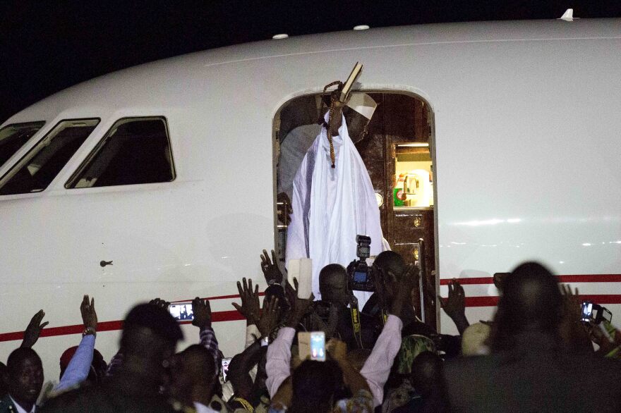 Gambia's defeated leader Yahya Jammeh waves to supporters as he departs from Banjul airport on Saturday.