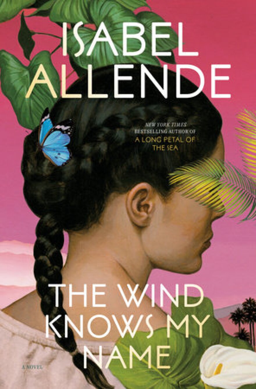 The cover of "The Wind Knows My Name" by Isabel Allende features an illustration of a person with dark braided hair looking away. The background is a warm pink, with tropical plants.