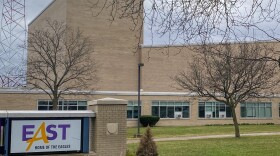 East High School is shown with the school name on a monument out front, and the building in the background.