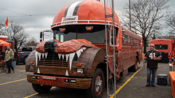 wood paneled bus is decorated to look like giant dog wearing Cleveland Browns helmet