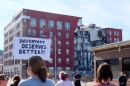 Protesters stand out the collapse site of an apartment building in Davenport on May 30. 