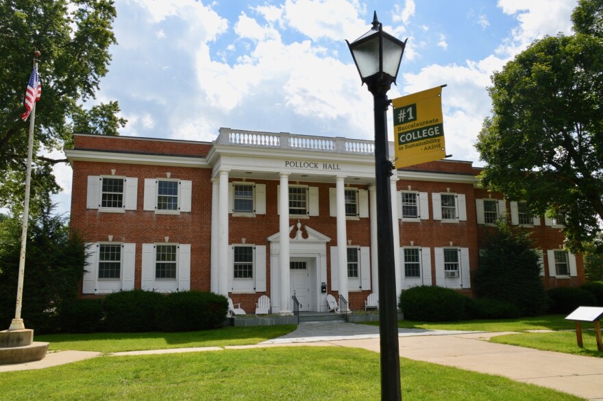 red brick college building with lamp in front.