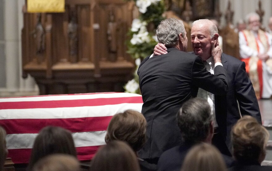Former President George W. Bush embraces former Secretary of State James Baker, right, after he gave a eulogy during the funeral for former President George H.W. Bush at St. Martin's Episcopal Church, Thursday, Dec. 6, 2018, in Houston.