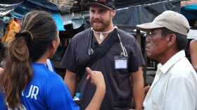 Dave Ohlson speaks with potential patients in a market in Iquitos, Peru.