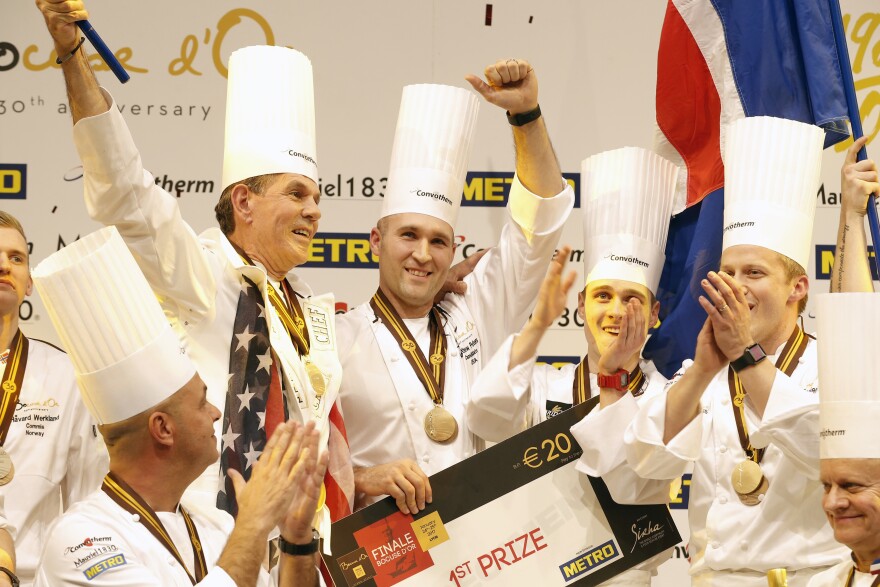 U.S. chef Mathew Peters (center), celebrates on the podium with teammates after winning the "Bocuse d'Or" trophy, in Lyon.