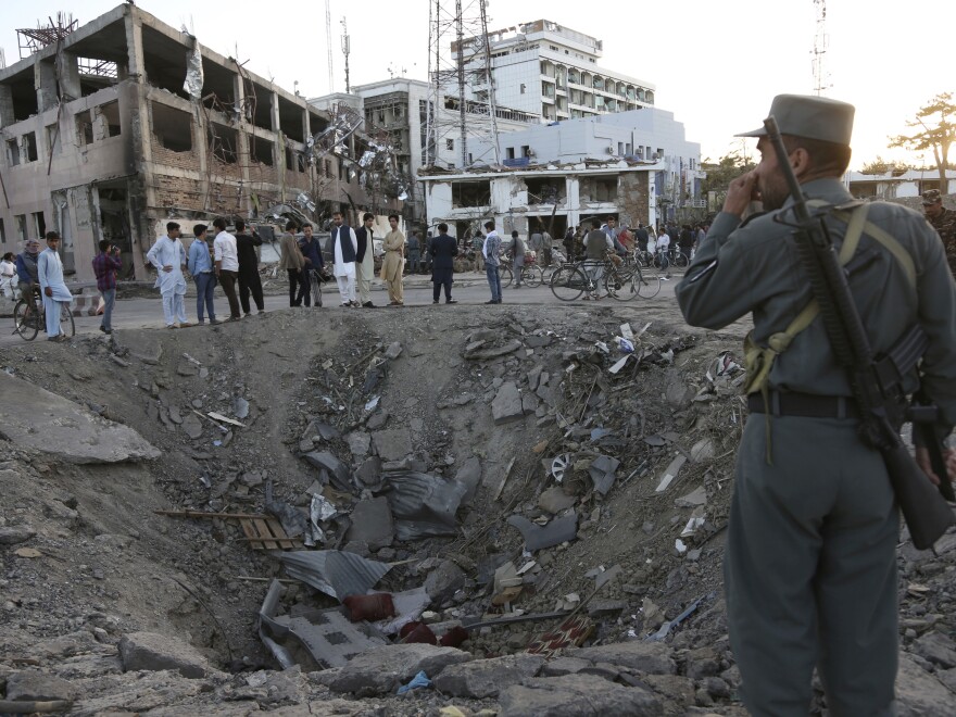 Security forces stand next to a crater created by a massive explosion in front of the German Embassy in Kabul on Wednesday.