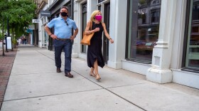 A couple wearing protective masks walk through Cincinnati's Over-the-Rhine District on Saturday, May 16, 2020. The city of Cincinnati and Hamilton County now have mask mandates that go into effect this week.