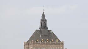 This file photo shows the Kodak Tower and an airplane flying overhead.