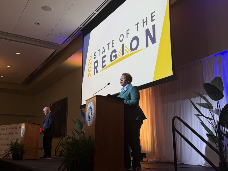 Two presenters stand on stage at a University of South Florida ballroom during the 2026 State of the Region event. 