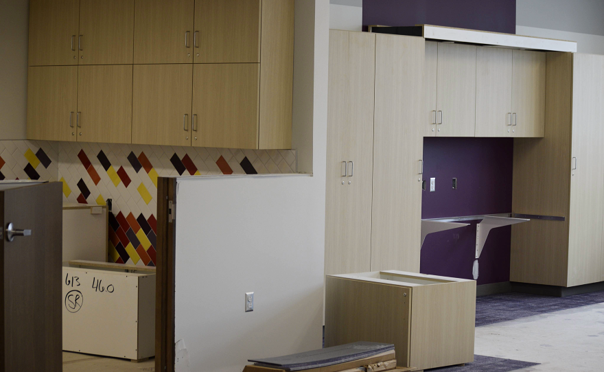 An incomplete room has a number of cabinets and a space for a sink to be installed.