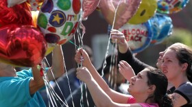 Balloons are placed Tuesday in front of the home of Gina DeJesus in Cleveland. DeJesus was found Monday, along with Amanda Berry and Michelle Knight, after disappearing nine years ago.