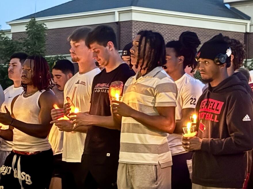 William Jewell football players hold candles during the vigil for MichaJo Barnett.