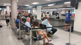 Clients wait in line at the downtown Gainesville branch of the Alachua County Tax Collector's Office. Local tax collector's offices experienced higher traffic after the newly effective drop in vehicle tag fees.