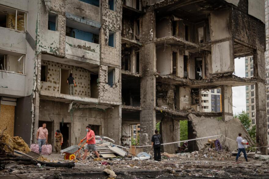 Local residents clear a territory at a residential building damaged by Monday's Russian missile attack in Kyiv, Ukraine, Tuesday, July 7, 2026. (Dan Bashakov/AP)