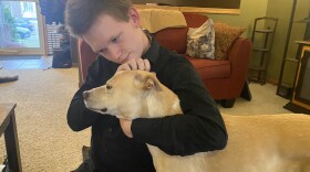 Lexi Dutcher, 17, hugs one of the family's dogs during a recent visit home to Wichita. The Wichita school district was ordered to pay Lexi's parents more than $250,000 for private school tuition and ongoing expenses for denying special education services.