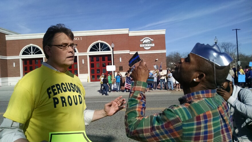 Police supporter Blake Ashey and protester Meldon Moffitt exchange words across the street from the Ferguson Police Department.