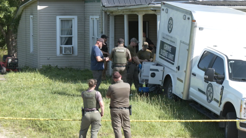 Law enforcement officers gather outside a home in Vinton County where four people were arrested Tuesday on charges of child endangerment.