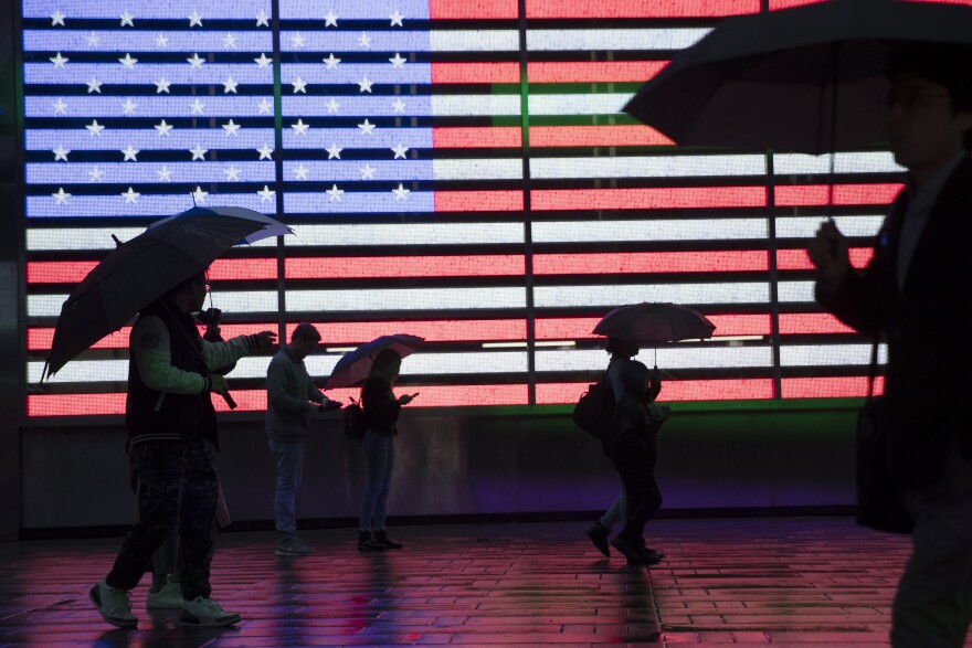 FILE - In this April 26, 2019, file photo, visitors to New York's Times Square use umbrellas to shield themselves against the rain as they walk past the Armed Forces Recruitment Center. The U.S. Census Bureau is creating tighter privacy controls in response to new fears that census questions could threaten the privacy of the people who answered them.