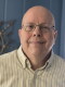 A man with glasses and a button-down dress shirt.
