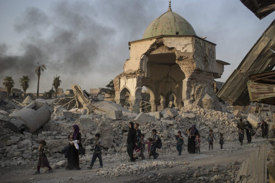 Fleeing Iraqi civilians walk past the heavily damaged al-Nuri mosque in the Old City of Mosul, Iraq, Tuesday, July 4, 2017. (Felipe Dana/ AP)