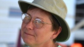 A photo of KCUR volunteer Becky Welch in a green t-shirt and sun hat