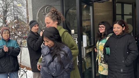 A woman walks out of a building with her sister behind her