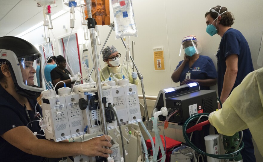 Maria Arechiga (center) helps move an intubated COVID-19 patient to a private room. The patient died later that day. Multiple COVID-19 deaths in one day are not rare at the hospital.