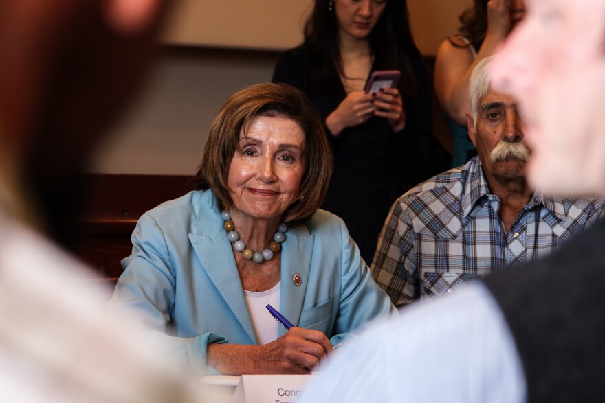 House Speaker Nancy Pelosi listens as farmer Zach Withers describes what he and others have experienced during the wildfires in Northern New Mexico