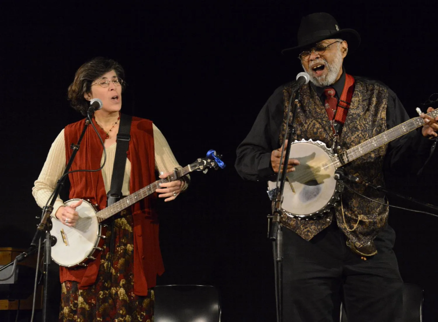 Sparky Rucker (right) and his wife Rhonda (left) play the banjoes together on-stage while singing.