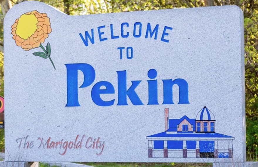 A concrete sign reads "Welcome To Pekin" along with the nickname "The Marigold City."