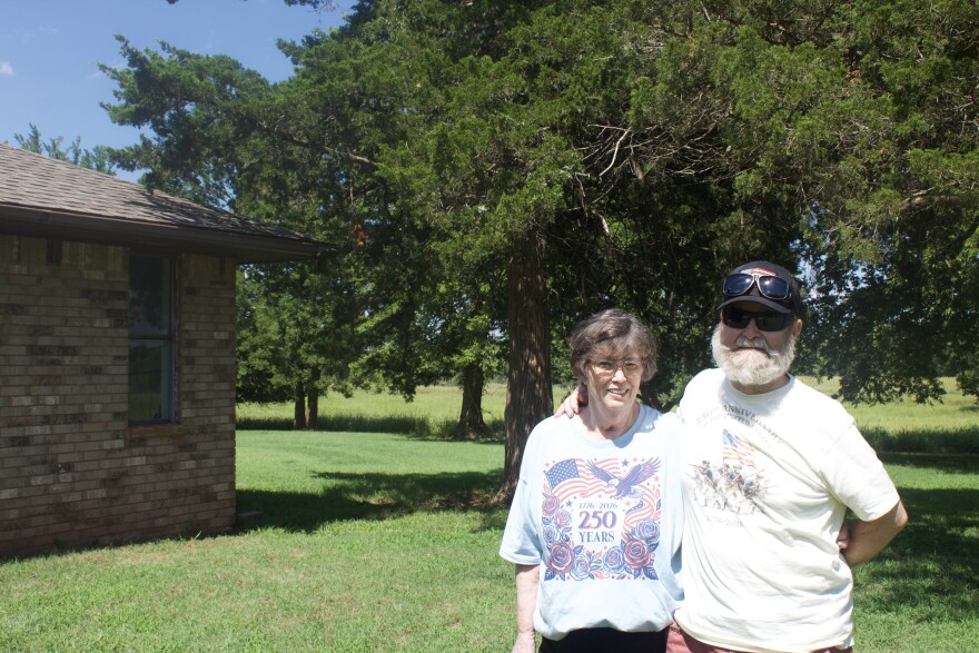 Linda and Lewis Rainey stand next to their Guthrie home on July 7, 2026. They own 400 acres of fields and farmland, some of which Linda Rainey's great-grandfather acquired shortly after the 1889 Land Run. The legacy of the land and her ancestors' gumption, she said, are motivating her to fight a transmission line that could go across two 80-acre tracts of their property.