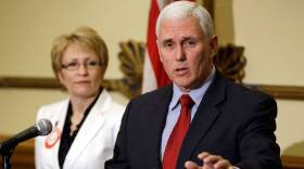 Indiana Gov. Mike Pence, right, talks about the state budget proposed by Senate Republicans as Lt. Gov. Sue Ellspermann looks on during a press conference on April 4, 2013.