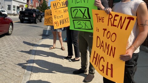 Protestors hold up signs including one reading 'The Rent is too damn high' during a rally in Newmarket in September.