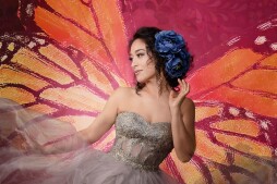 A woman in a dress against a painted butterfly background