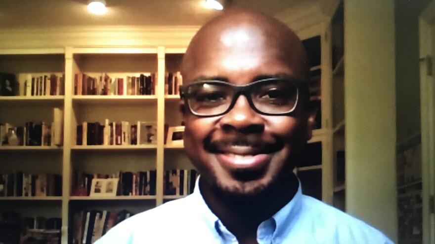 man smiling in front of a bookcase