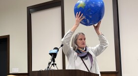 Djamil Graham of Boston holds up an inflated globe as she speaks during the public comment period at Monday's meeting of the Nuclear Decommissioning Citizens Advisory Panel at Plymouth Town Hall.