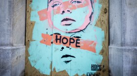 A mural that says "Hope" painted on a boarded-up business on Sixth Street.