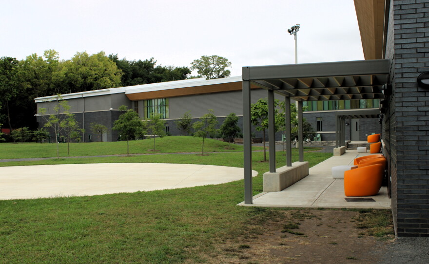 The recreation yard includes shaded lounge space facing a half court basketball pad.