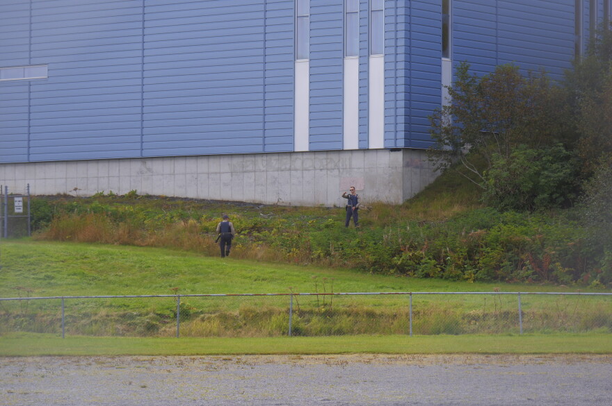 Troopers scan the woods behind the softball field on Mill Bay Road for a bear on Sept. 25.