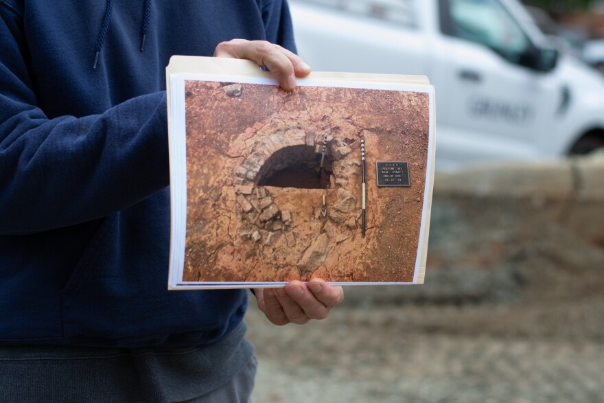 Benjamin Ford, principal of Rivanna Archaeological Services, holds up a photo of an old well discovered during the study.