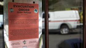 A red sign is stuck to a glass door. 