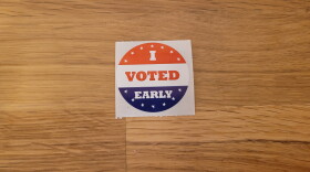 "I voted early" sticker on a wooden table