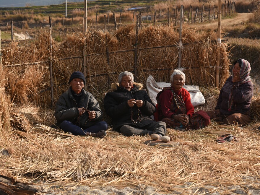 A group prays before a small <em>stupa</em>, a mound-like religious structure. Bhutan is a country centered in the teachings and values of Buddhism. Spirituality, meditation and the sense of peace Bhutanese derive from worship are considered strong components of national happiness.<strong></strong>