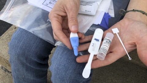 Solutions Oriented Addiction Response organizer Brooke Parker displays an HIV testing kit in Charleston, W.Va., on March 9, 2021.
