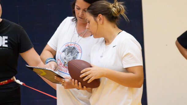 Wichita Northwest High School sophomore Avery Soetaert consults with her coach Brooke Collins during flag football practice at the school.