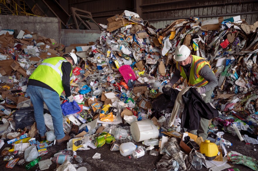 Tom Gaffey (left), MIRA’s director of recycling and enforcement, and inspector Dan Heisler pick out contaminants from a load of single-stream recycling at the MIRA intermediate processing center in Hartford. lf an incoming load of recyclables wasn't heavily contaminated with trash, it got sent to a recycling center in Berlin for sorting and later was sold or shipped out of state. Materials were sorted in the Hartford facility until the end of April 2021, when the operation was outsourced to the Murphy Road Recycling Inc. facility in Berlin.