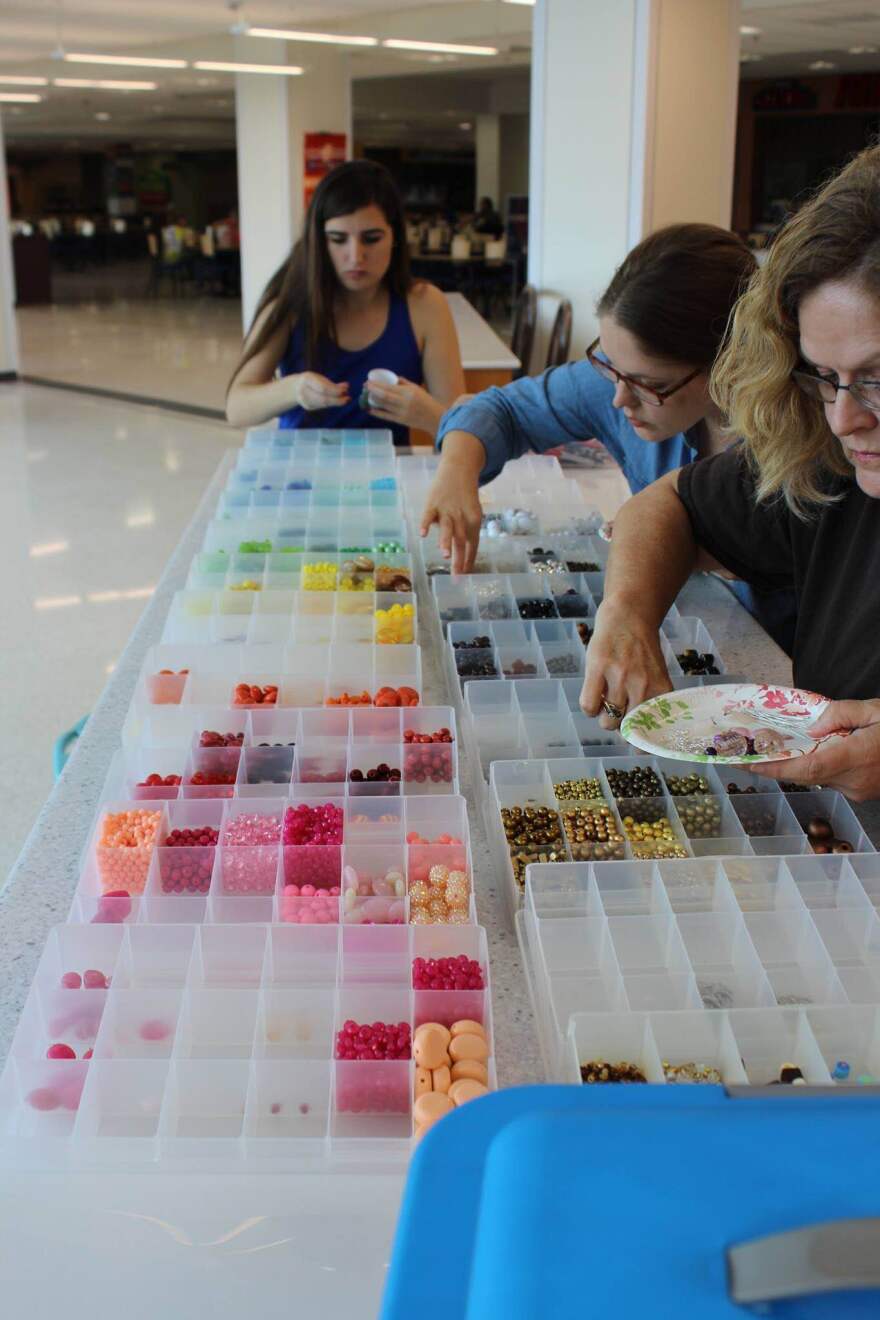 (Left to right) sophomore Daniella Pareja, post BAC student Karley Post and Post's mother Susie Osborne pick out beads for earrings. (Photo courtesy of Carson Smith.)