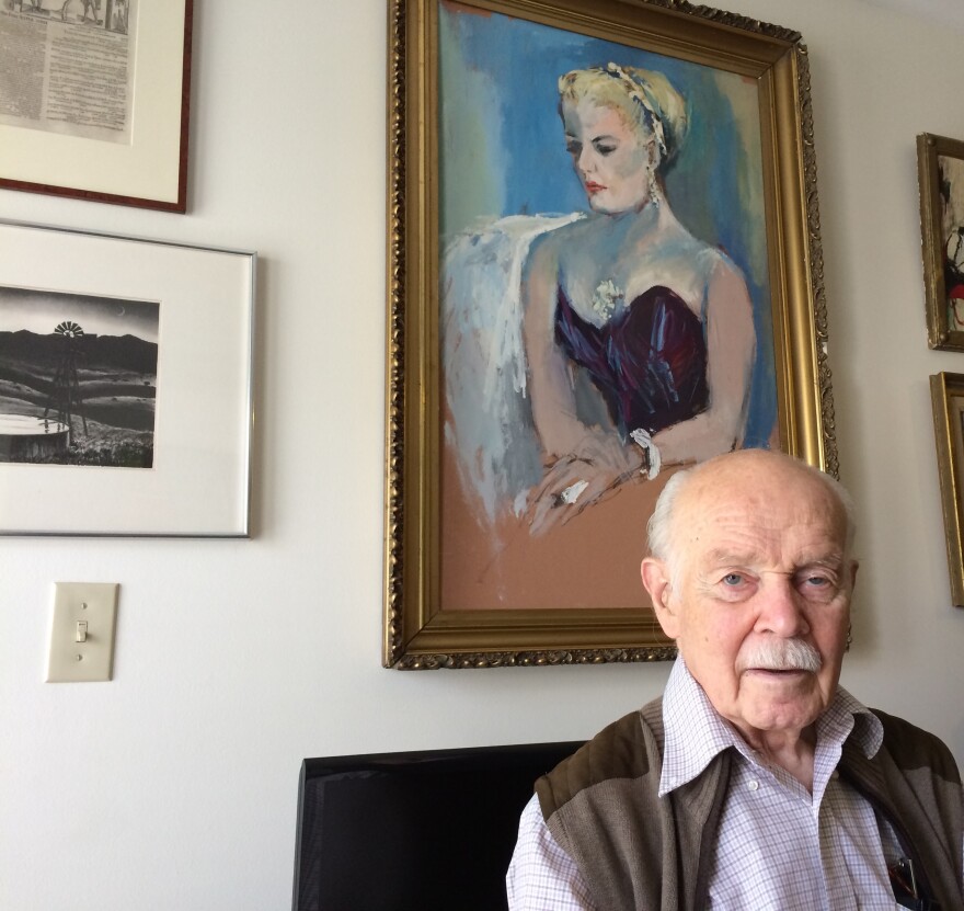 James Benner at his apartment in Morgantown. On the wall behind him is a portrait of his late wife, Frances Yeend, as well as a few items he's keeping from their shared collection.