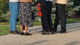 legs of people standing on a driveway